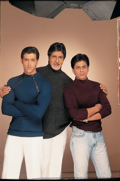 three men standing next to each other with their arms crossed