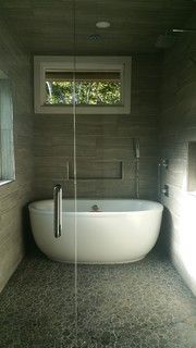 a bathroom with a bathtub and window in it