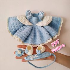 a crocheted baby outfit and booties is being held by someone's hand