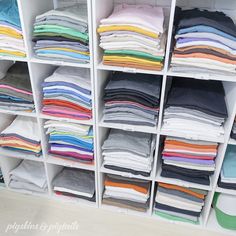 a closet filled with lots of folded clothes