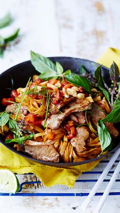 a skillet filled with pasta, meat and vegetables