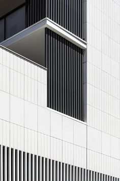 an airplane is flying in front of a building with black and white stripes on it