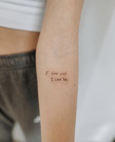 a woman's arm with a tattoo saying i love you in cursive writing