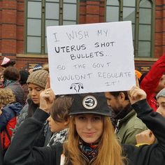 a woman holding up a sign that reads i wish my uteros shot bulletets so the government wouldn't recupate it