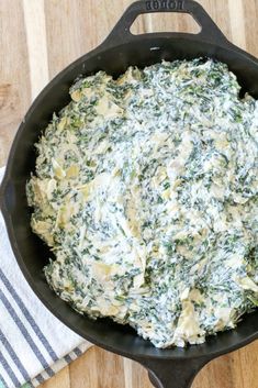 spinach dip in a cast iron skillet on a wooden table