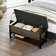 an open suitcase sitting on top of a wooden floor next to a bed with white sheets