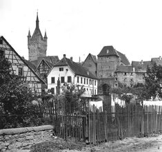 an old black and white photo of a town with tall buildings on the other side