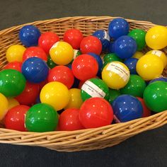 a basket filled with lots of colorful balls