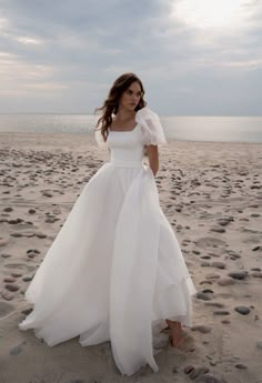 a woman in a wedding dress on the beach