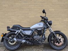 a motorcycle parked in front of a brick wall