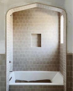 a bath tub sitting inside of a bathroom next to a window with no curtains on it