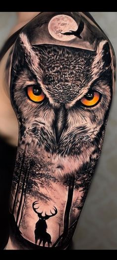 an owl with orange eyes and deer in the woods is shown on this man's arm