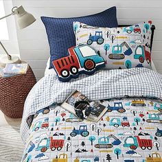 a child's bed with construction themed sheets and pillows