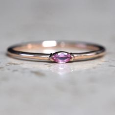 A dainty marquise pink sapphire is at the center of our "Wink" ring, giving you just a little wink of sparkle!   - Marquise stone measures 4mm x 2mm - Handcrafted out of solid 10K or 14K gold - Round band measures 1.2mm in width Processing Times -  Current processing time is 1 - 3 weeks.  Each Item is handmade to order with love and care! In Stock Items -  Contact Liesel Love with any rush order questions, or to see if we have anything ready made and in stock.  Returns -  Liesel Love does take r Gift Marquise Sapphire Ring, Marquise Sapphire Ring As Gift, Fine Jewelry Marquise Pink Gemstone, Fine Jewelry Pink Marquise Ruby Ring, Pink Marquise Ruby Ring Fine Jewelry, Pink Marquise Ring For Anniversary, Pink Marquise Gemstone Rings, Pink Marquise Promise Ring, Pink Marquise Gemstone Jewelry