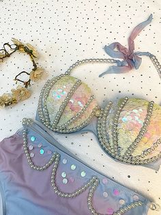 two bras with sequins are laying on a table next to some beads