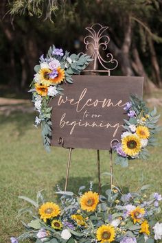 a welcome sign with sunflowers and greenery