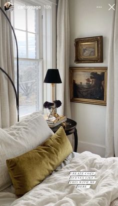 a bed with white sheets and pillows next to a painting on the window sill