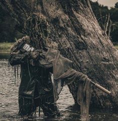 two people standing in the water next to a tree with net covering it's face