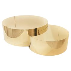 two round brass coffee tables sitting on top of each other in front of a white background