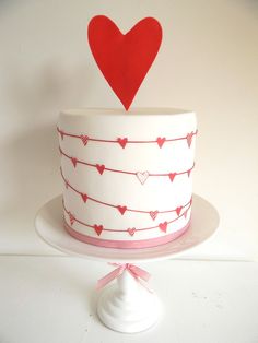 a white cake with red hearts on top