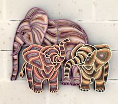 two elephants are standing next to each other on the wall with white bricks behind them