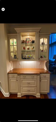 a kitchen with white cabinets and wooden counter tops in the middle of a hardwood floor