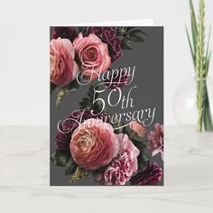 a happy anniversary card with pink roses and purple carnations on a gray background