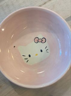 a pink bowl with a hello kitty face painted on it