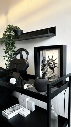 a black desk with a statue of liberty in the frame and other items on it