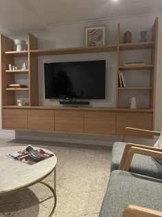 a living room filled with furniture and a flat screen tv on top of a wooden entertainment center