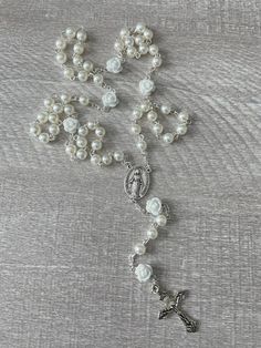 Handcrafted Catholic prayer rosary. Traditional chain style five decade rosary.  It is made with a delicate silver plated crucifix and matching silver Virgin Mary medallion with white rose beads and 6mm faux pearls. Each bead is hand placed, turned and connected.  This rosary is perfect for a bridal rosary, Holy Communion or Confirmation Rosary.  Handmade in Florida with love. ❤️ Silver Pearl Rosary For First Communion, Silver Miraculous Medal For Wedding, Silver Miraculous Medal Jewelry For Wedding, Silver Crucifix For Wedding, Rosary Garden, Plant City, Rosary Catholic, Last Minute Gifts, Virgin Mary