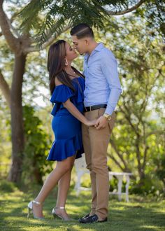 a man and woman standing next to each other in the grass