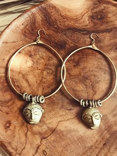 "Handmade brass hoops featuring African masks and textured brass beads that were made by African artisans. *The mask on each pair of hoops will vary is style and size. No 2 are alike. DETAILS: Metal: Brass Size:3\" Gold plated ear wire Ships with polishing cloth *The mask and beads have been left un-polished and May feature some patina. Return to shop: Afrohemien.etsy.com Like and Follow Afrohemien for updates, sales, coupons and surprise giveaways Instagram/Blog: instagram.com/Afrohemien Tumblr Spiritual Brass Hoop Earrings, Artisan Bronze Hoop Earrings, Artisan Brass Hoop Earrings, Unique Brass Hoop Earrings, Handmade Brass Hoop Plug Earrings, Artisan Bronze Hoop Earrings With Ear Wire, Bohemian Small Hoop Hand Forged Earrings, Bohemian Gold Hand Forged Hoop Earrings, Handmade Symbolic Brass Hoop Earrings