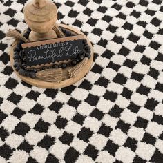 a black and white checkered rug with a sign that says, a unique life is beautiful life