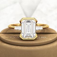 an emerald cut diamond ring with baguets on top