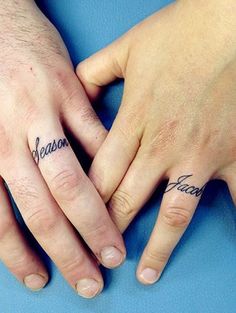 two people holding hands with tattoos on their fingers and the words reason written in cursive writing