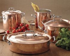 copper pots and pans with strawberries on the table