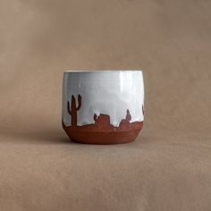 a white and brown cup sitting on top of a table