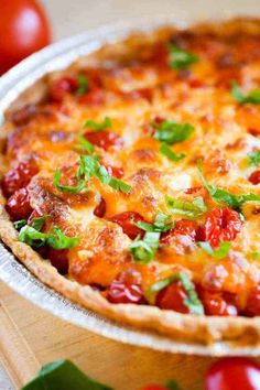 a cheesy pizza with tomatoes and green garnish on the top is ready to be eaten