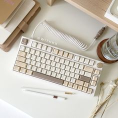 a computer keyboard sitting on top of a white desk next to a bottle of water