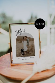 a table with a photo and a feather on it that says, tablo's