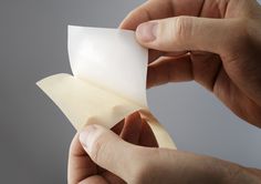 a person holding a piece of white paper in their left hand with the other hand