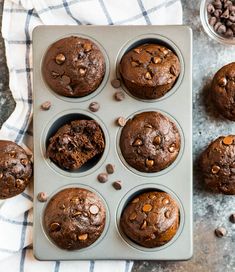 chocolate muffins in a muffin pan on a towel