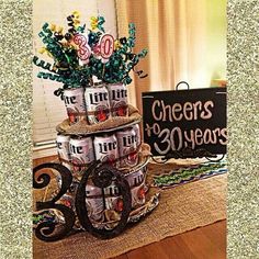 a cake made to look like cans with flowers in them and the words cheers to 30 years on it