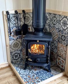 a stove in a corner with tile on the wall and flooring around it,