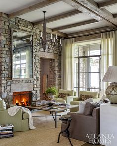 a living room filled with furniture and a fire place in front of a stone fireplace