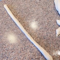 a long piece of bread sitting on top of a counter next to an uncooked garlic