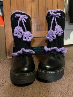 a pair of black boots with purple crocheted bows and skulls on the side