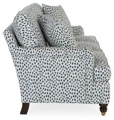 an upholstered chair with blue and white polka dots on the back, sitting in front of a white background