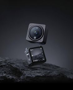 an image of a camera on top of a rock and another object in the air